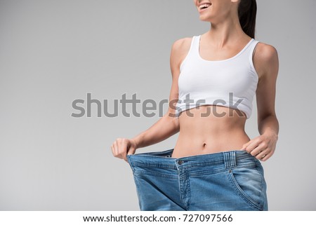 Joyful slim girl showing result of diet Royalty-Free Stock Photo #727097566