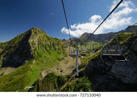 Mountain cableway stretching down over beautiful early autumn mountain landscape.
