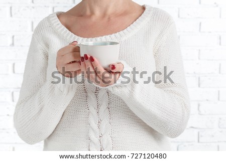Woman's hands holding cup of coffee