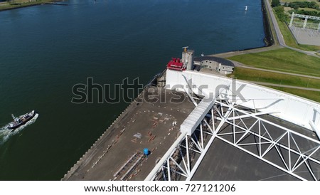 Aerial photo of Dutch storm surge barrier following ship moving through gates the construction of Maeslantkering was part of Europoortkering project which was final stage of Delta Works