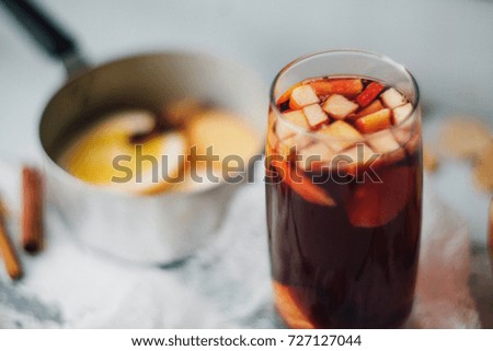 hot drink, mulled wine red, ingredients for mulled wine: orange, Apple, cinnamon, cloves, ginger in a bowl on wooden background light