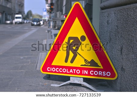 sarcastic street sign, says "chocolate in progress" in Italian