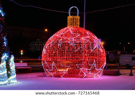 Street decoration and lighting from a garland in the form of a big New Year's toy-ball