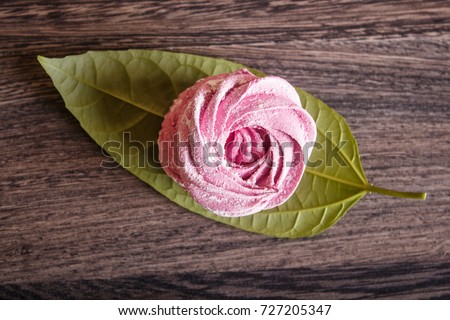 single pink  homemade marshmallows on a gray wooden background. top view.