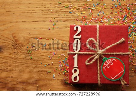wooden numbers forming the number 2018, For new year 2018 on rustic wooden with red gift box and brown ribbon. empty copy space for inscription or objects. happy new year background