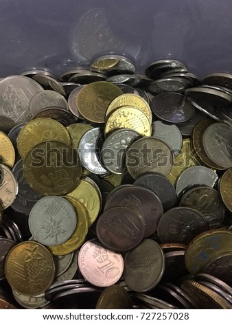 The Malaysia Coins in the glass jar . low light, selective focus, blur image