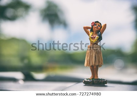 Hawaii road trip - car hula dancer doll dancing on the dashboard in front of the ocean. Tourism and travel freedom concept. Royalty-Free Stock Photo #727274980
