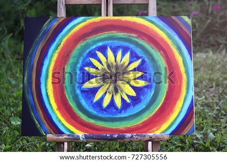 Abstract painting on canvas in the summer park. Yellow flower and rainbow circles.