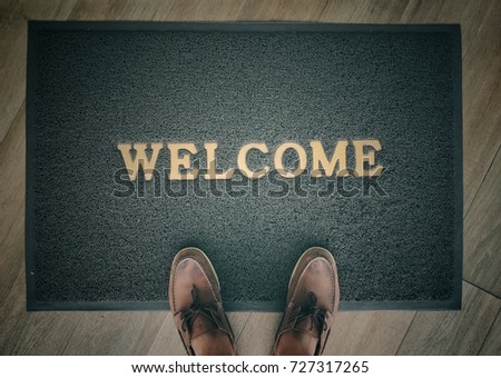 Welcome carpet gray color with shoe on it, dark vintage tone.