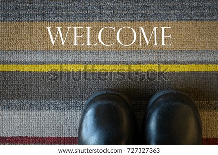 Welcome carpet with leather shoes on it.