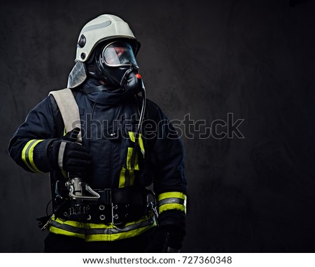 Studio portrait of firefighter dressed in uniform and an oxygen mask.