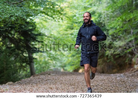 a man running in forest Royalty-Free Stock Photo #727365439
