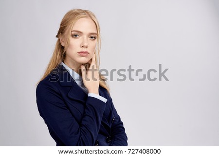 business woman straightens hair looking at camera on gray background, place to copy                               