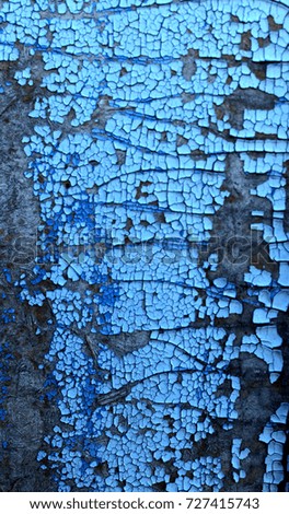 Texture of shabby hardboard surface with peeling blue paint, abstract rustic background. Soft focus.