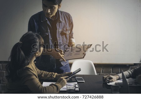 Young employees are meeting in the meeting room. They have the attitude stressed. There is a blank white board mounted on the wall. Copy space for text.