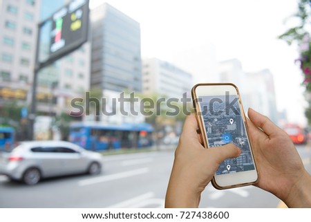Hand using smart phone searching location on satellite navigation application and network connection over traffic transportation in city, internet of things, satellite navigation system app concept