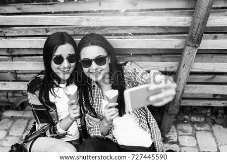 Two pretty brunette girls making selfie outdoor