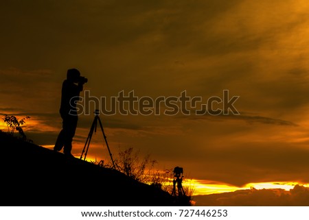 silhouette photographer take photo of sunset