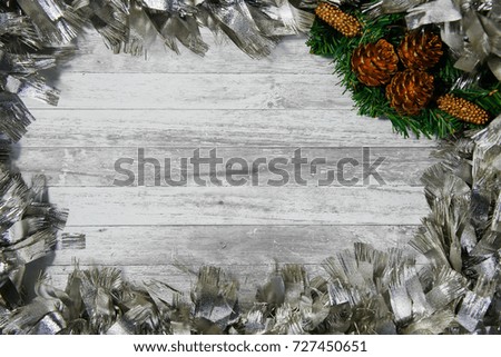 Christmas border with holly, mistletoe , christmas tree and silver ornamental on gray wood texture with copy space