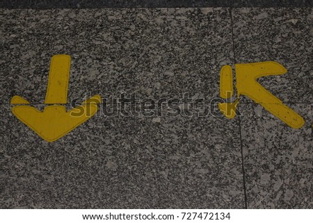 two yellow arrow signs for walk
