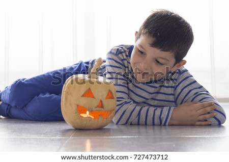 Cute boy with pumpkin in Halloween