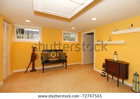 Yellow basement room design with black bench