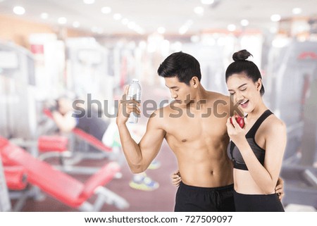 Young fitness  man and his girlfriend in training gym . Fitness and healthy lifestyle concept. 