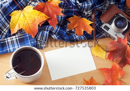Tea and photo on a table with autumn leaves