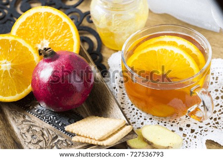 Cup of hot tea with honey, ginger and oranges. Autumn and winter evening relaxation idea. 
