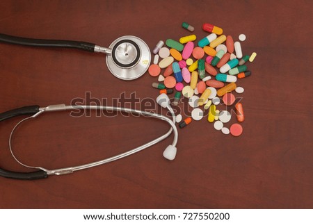Drugs and stethoscope on wooden table