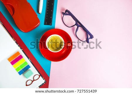 bright office supplies on a multi-colored combined background with glasses and an espresso cup. Flat lay. Top view. Copyspace