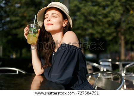 Picture of brunette in hat with glass