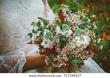 Bride showing off her beautiful boho flowers bouquet. Boho / vintage image with copy space for: amazing boho wedding flowers, bohemian dress,
women fashion, florist and other related subjects.