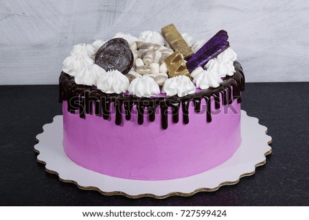 a pink cream cheese cake with chocolate sweets
