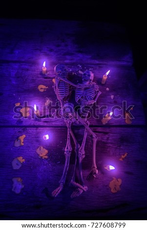 Cute little skeleton on wooden floor and candle light around. Halloween Theme