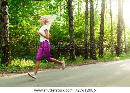 Picture of sports woman jogging on road