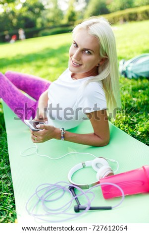 Photo of sports girl with phone on rug