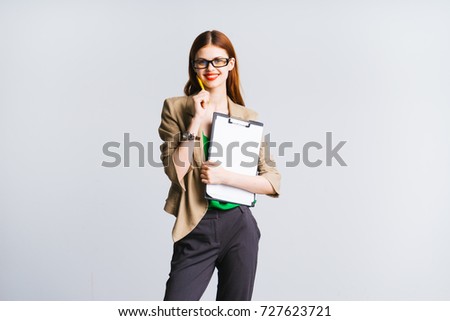 cute beautiful girl in a suit looking at the camera and holding a folder A4