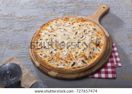 Italian Delicious Fresh Hot Mix Baked Pizza with Melting Cheese, sliced mushrooms , tomato sauce and cheddar serving on grey textured rustic background.