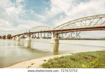 Maria Valeria bridge joins Esztergom in Hungary and Sturovo in Slovak republic across the Danube river. Transportation theme. Architectural scene. Yellow photo filter.