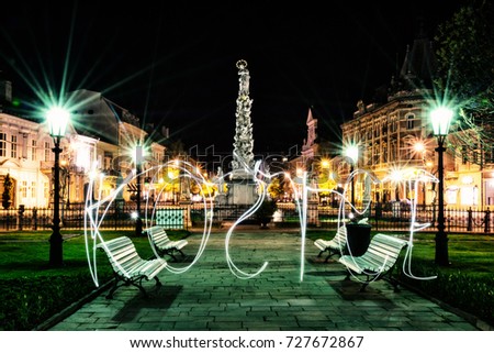 Plague column in Kosice city, Slovak republic. Night scene. Writing with light - art technique. Architectural scene. Old photo filter.