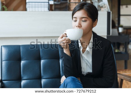 Young Asian business woman relaxing with a cup of coffee 