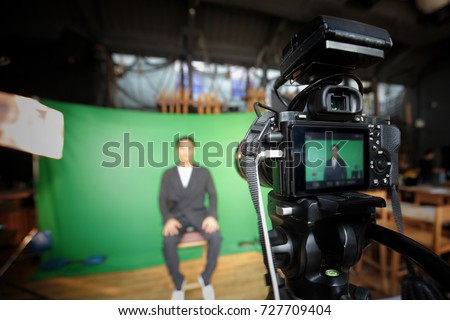 Videographer taking video camera, camera man working with professional equipment film on green screen.