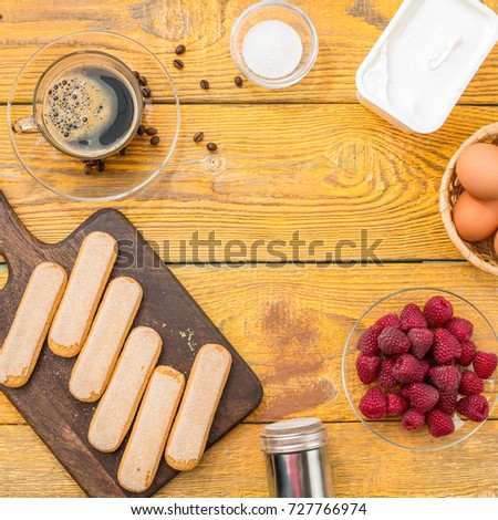 Picture of wooden table with ingredients for tiramisu, raspberry, space for text