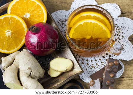 Cup of hot tea with honey, ginger and oranges - top view. Autumn and winter evening relaxation idea. 