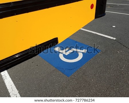 yellow school bus and blue handicapped parking symbol