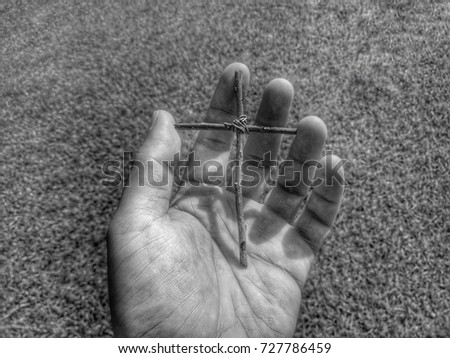 Close up hand holding strength Christ cross in monochrome picture process