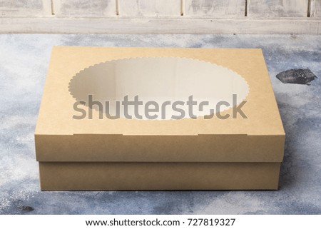 Cardboard box with a transparent cover on a light background. Transparent window