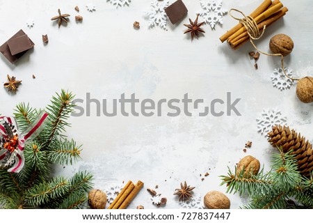 Ingredients for Christmas baking - chocolate, cinnamon, anise and nuts on a stone or slate background. Seasonal, food background.