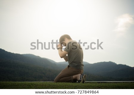 A man is praying to God on the mountain. Royalty-Free Stock Photo #727849864